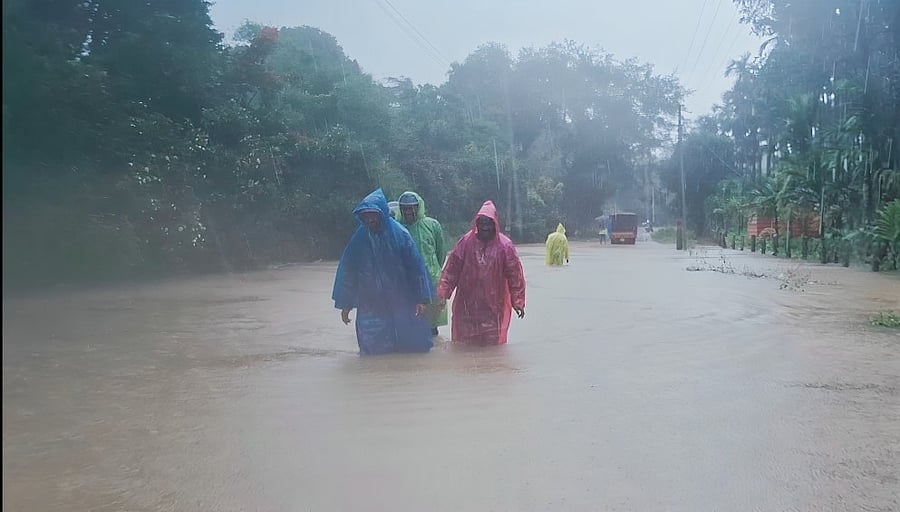 <div class="paragraphs"><p>Villagers wading through knee-deep water at Nabala village in Thirthahalli taluk as the river Malathi is flowing above the danger level on Saturday.</p></div>