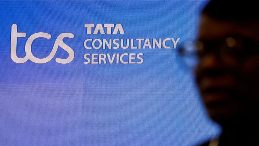 <div class="paragraphs"><p>A man walks past a logo of Tata Consultancy Services (TCS).</p></div>