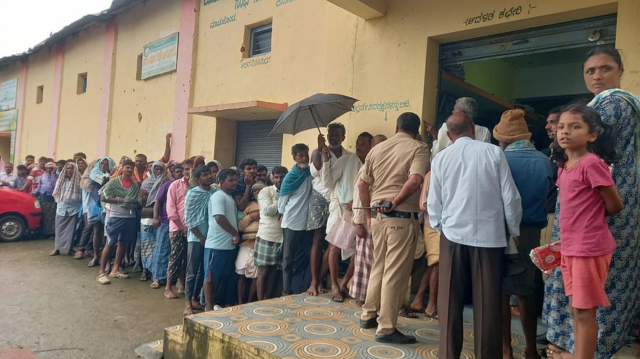 A file photo of farmers waiting in a long queue for purchasing urea fertiliser at a primary agricultural cooperative society in Mayakonda of Davangere district.