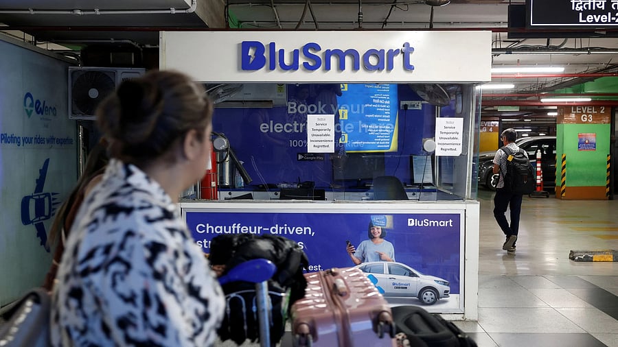 <div class="paragraphs"><p>Travellers move past a closed BluSmart electric car booking counter at T3 parking lot at the Indira Gandhi International Airport in New Delhi.</p></div>