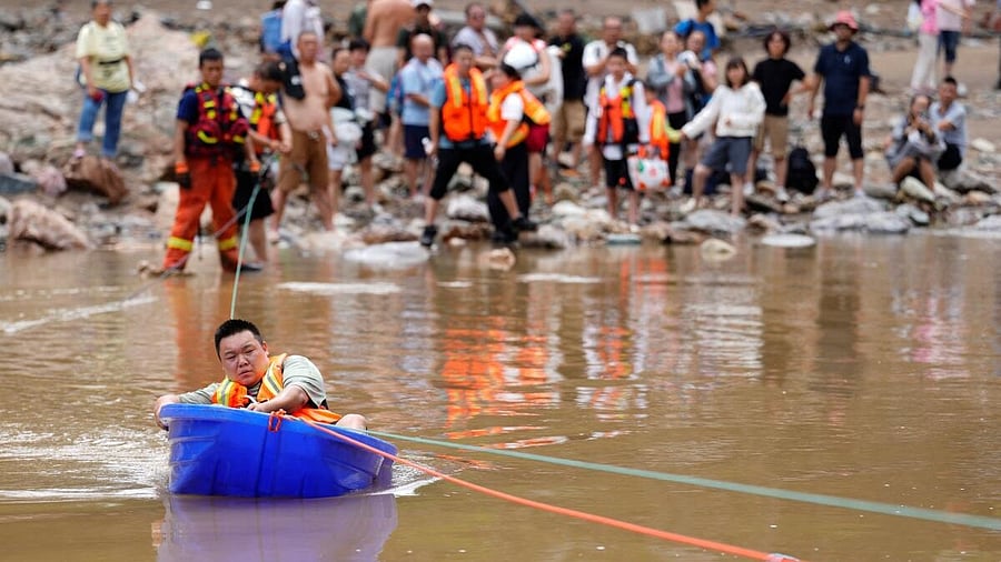 <div class="paragraphs"><p>Man sits in a plastic boat after heavy rainfall flooded Huairou district of Beijing</p><p></p></div>