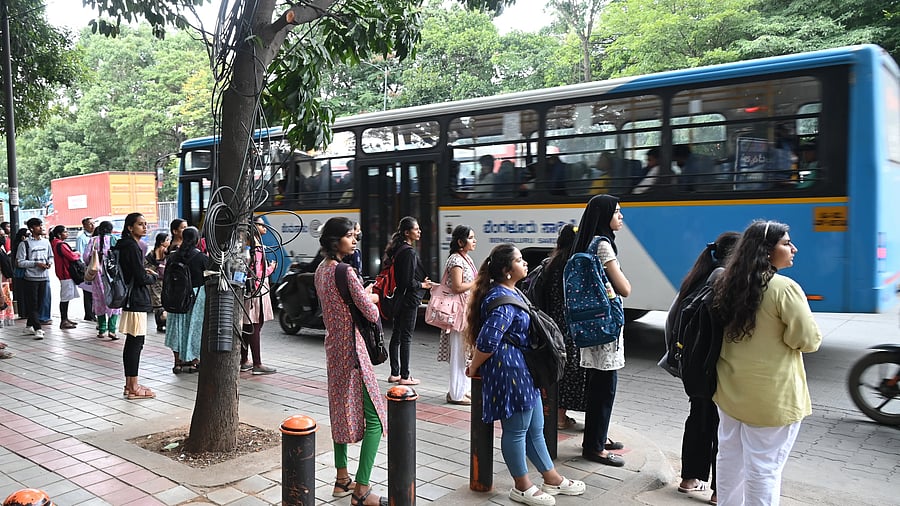 <div class="paragraphs"><p>Students wait for a bus at a stop on Seshadri Road, K R Circle, on Tuesday afternoon.</p></div>