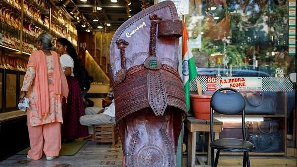 <div class="paragraphs"><p>Customers shop for 'Kolhapuri' sandals, an Indian ethnic footwear, at a store</p></div>