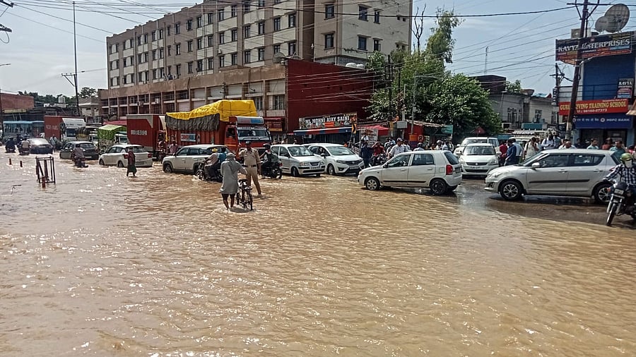 <div class="paragraphs"><p>Commuters wade through a waterlogged road after heavy rainfall, in Himachal's Una district, Saturday, Aug. 2, 2025. </p></div>