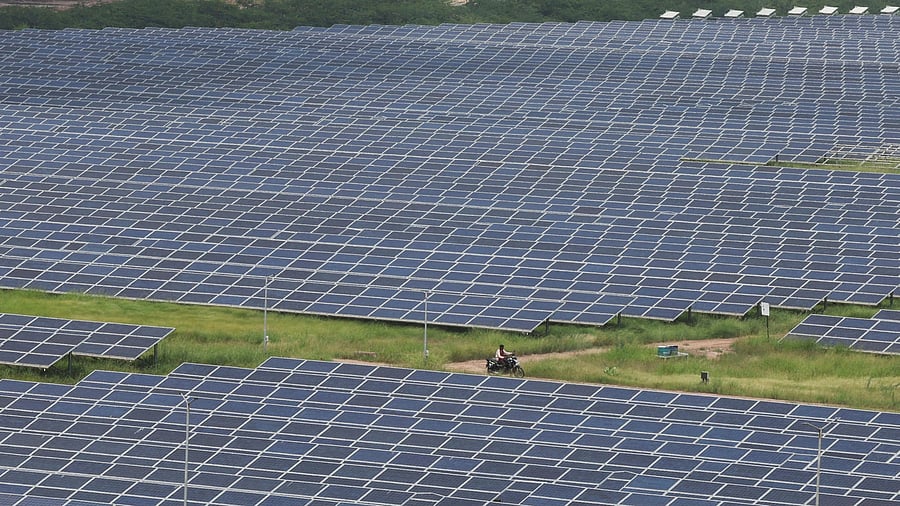 <div class="paragraphs"><p>A man rides a motorcycle along the solar panels in Gujarat Solar Park also called Charanka Solar Park at Patan district in Gujarat.</p></div>