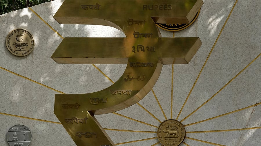 <div class="paragraphs"><p>A man speaks on his mobile phone next to an installation of the Rupee logo and Indian currency coins outside the Reserve Bank of India (RBI) headquarters in Mumbai, India, August 1, 2025. </p></div>