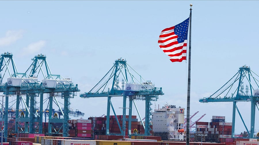 <div class="paragraphs"><p> An American flag flutters over a ship and shipping containers at the Port of Los Angeles, in San Pedro California, US</p></div>
