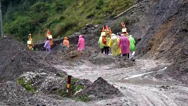 <div class="paragraphs"><p>Uttarkashi: 'Kanwariyas' returning from Gangotri make their way through a damaged road in flash flood-hit Dharali area, in Uttarkashi district, Uttarakhand</p></div>