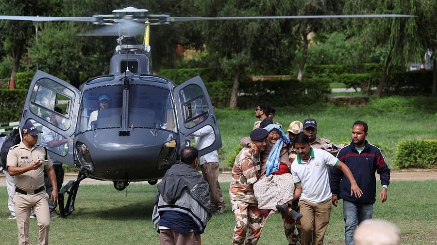 <div class="paragraphs"><p>Indo-Tibetan Border Police (ITBP) carry a woman after she was air lifted from Dharali, at a helipad in Matli</p></div>