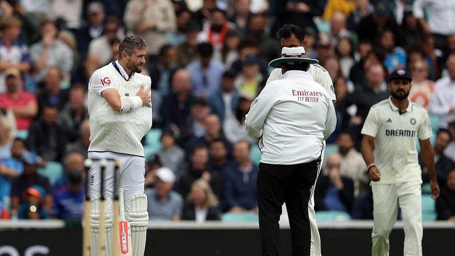 <div class="paragraphs"><p>England's Chris Woakes holds his arm as Prasidh Krishna talks with the umpire.</p></div>