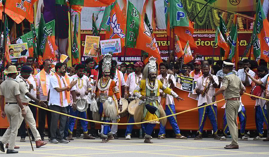 Policemen keep a vigil on the crowds and folk artistes gathered to catch a glimpse of the PM at Mehkri Circle.