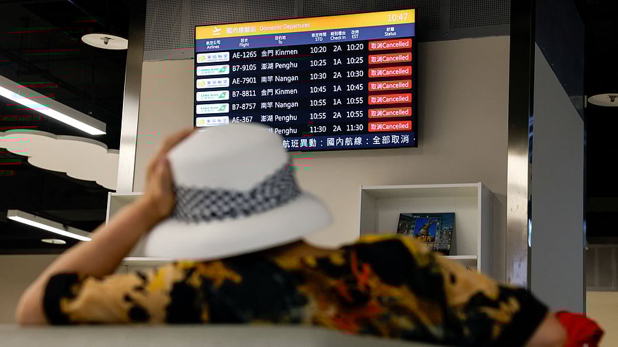 <div class="paragraphs"><p>A woman sits in front of a screen displaying information on cancelled domestic flights, as Typhoon Podul approaches the country, in Taipei, Taiwan August 13, 2025.</p></div>