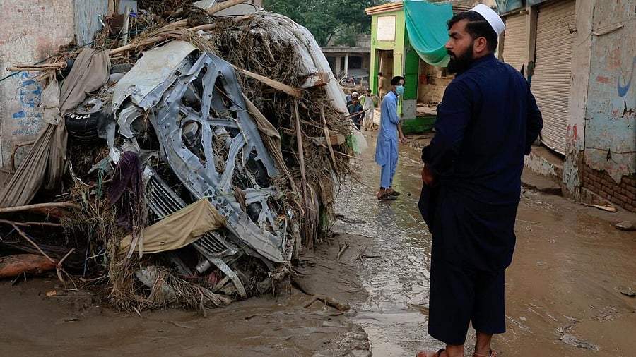 <div class="paragraphs"><p>A resident stands near a damaged vehicle following a storm that caused heavy rains and flooding, in Pacha Qaly Bazar in Buner district, in Khyber Pakhtunkhwa province, Pakistan. </p></div>