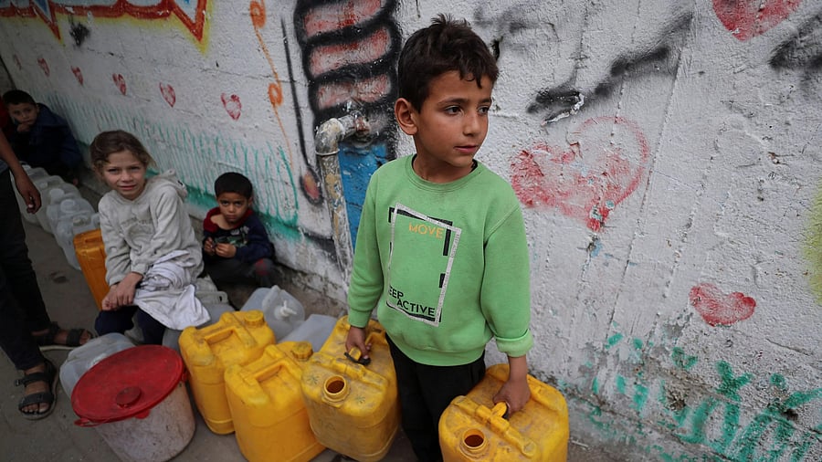 <div class="paragraphs"><p>Palestinian children gather near containers used for water in Gaza City.</p></div>