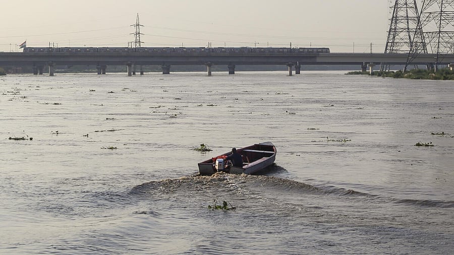 <div class="paragraphs"><p>A man rides a motorboat on the swollen Yamuna river</p></div>