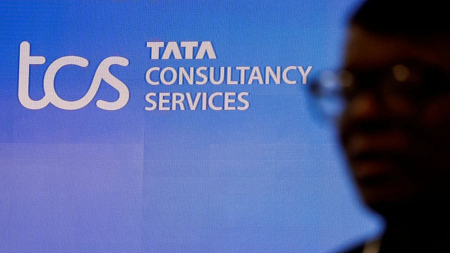 <div class="paragraphs"><p>A man walks past a logo of Tata Consultancy Services (TCS) </p></div>
