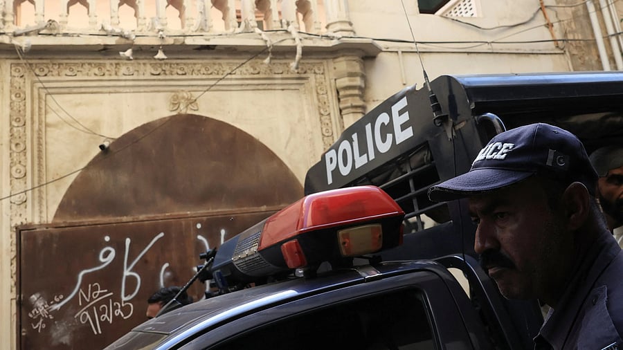 <div class="paragraphs"><p>A Pakistani police officer stands in front of a place of worship.</p></div>