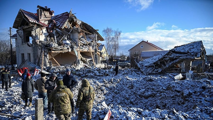 <div class="paragraphs"><p>Residents and bomb squad members stand in front of a house destroyed by Russian missile strike.</p></div>