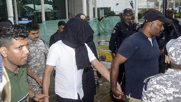 <div class="paragraphs"><p>Gangster Mayank Singh alias Sunil Meena, in white, being brought by the Jharkhand Anti-Terrorist Squad (ATS) following his extradition from Azerbaijan, at the Birsa Munda Airport, in Ranchi, Jharkhand.</p></div>