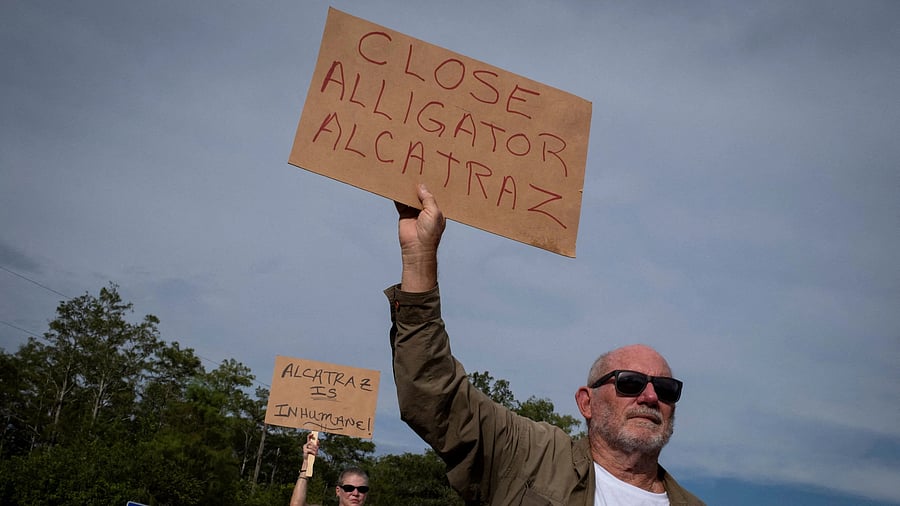 <div class="paragraphs"><p>People hold signs during a vigil in support of immigration detainees at the entrance of "Alligator Alcatraz" ICE detention center at the Dade-Collier Training and Transition Airport in Ochopee, Florida, U.S., August 10, 2025. </p></div>