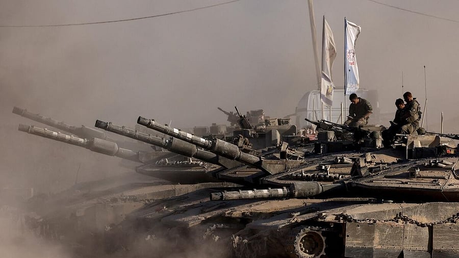 <div class="paragraphs"><p>Israeli soldiers sit on top of tanks at the Israel-Gaza border</p><p></p></div>