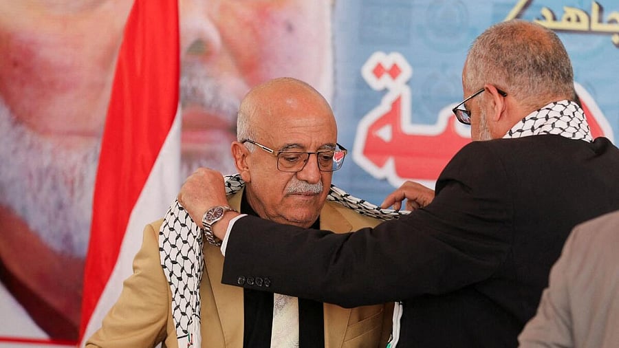 <div class="paragraphs"><p>FILE PHOTO: Representative of Hamas in Yemen, Muadh Abu Shammalah, gives the head of Houthi-led government Ahmad al-Rahawi a Palestinian keffiyeh during his visit to the Hamas office in Sanaa, Yemen.&nbsp;</p></div>