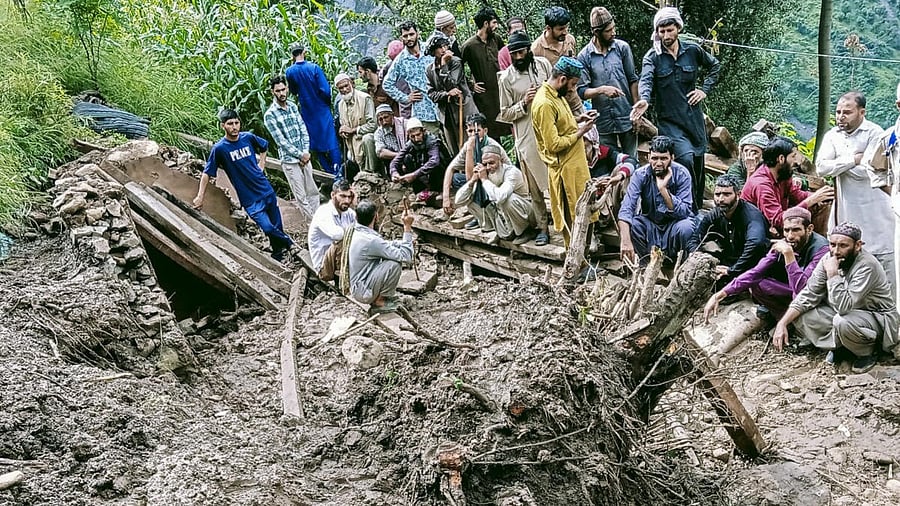<div class="paragraphs"><p>People sit amidst mud and debris during a search and rescue operation at a disaster-hit area, in Jammu and Kashmir.</p></div>
