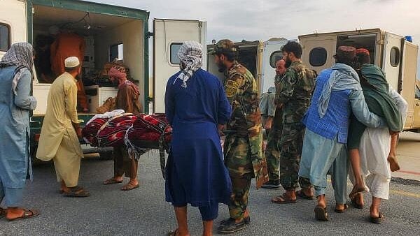 <div class="paragraphs"><p>Taliban soldiers and civilians carry earthquake victims to an ambulance at an airport in Jalalabad.</p></div>
