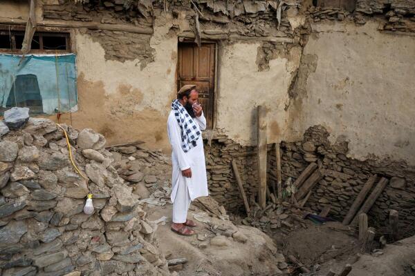 <div class="paragraphs"><p>An Afghan man reacts as he stands amidst the rubble of a collapsed house.</p></div>
