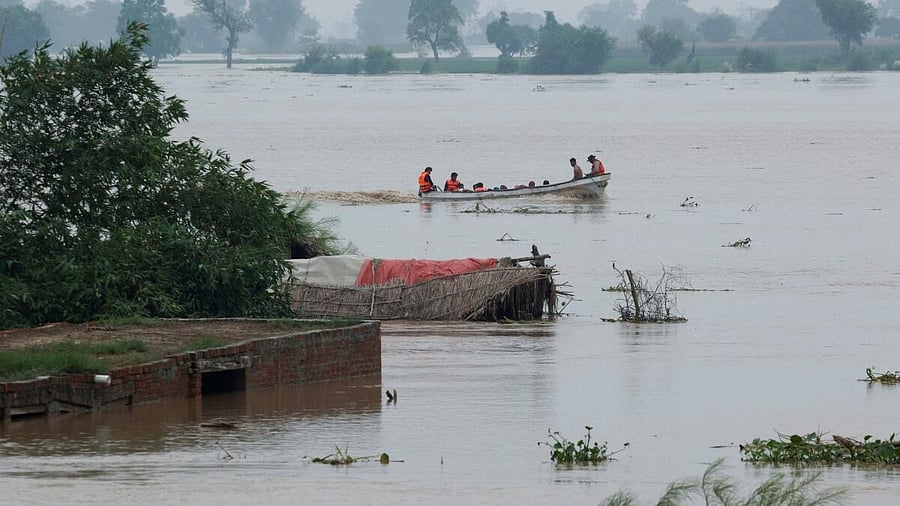 <div class="paragraphs"><p>A Rescue 1122 boat evacuates people from the flooded area past partially submerged houses, following the monsoon rains and rising water level of the Sutlej River, in Chanda Singh Wala village near the Pakistan-India border in Kasur district of the Punjab province, Pakistan.&nbsp;</p></div>