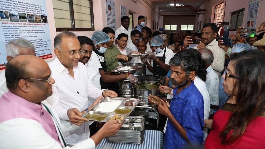 <div class="paragraphs"><p>Health Minister Dinesh Gundu Rao and Chaithanya Dasa, Communication Manager at ISKCON, distribute food at the launch of the meal programme on Tuesday.</p></div>