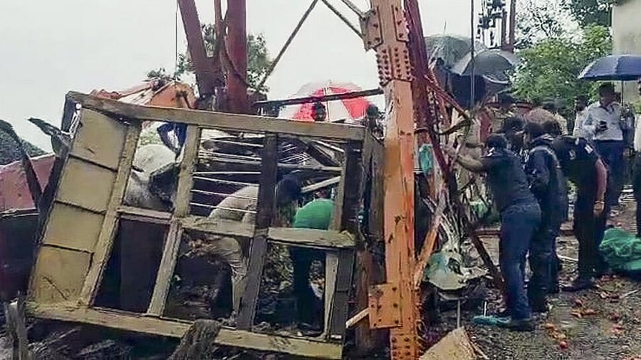 <div class="paragraphs"><p>Officials and others stand near the site where the cable wire of a cargo ropeway snapped, killing at least six people, at the Pavagadh Hill temple, in Panchmahal district, Gujarat, Saturday, Sept. 6, 2025.</p></div>