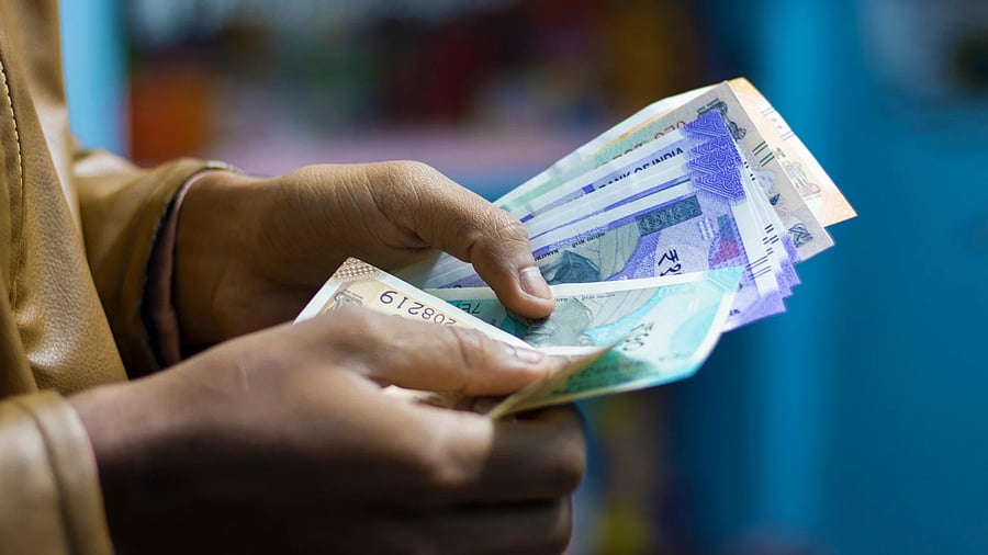 <div class="paragraphs"><p>Closeup view of a man counting Indian currency</p></div>