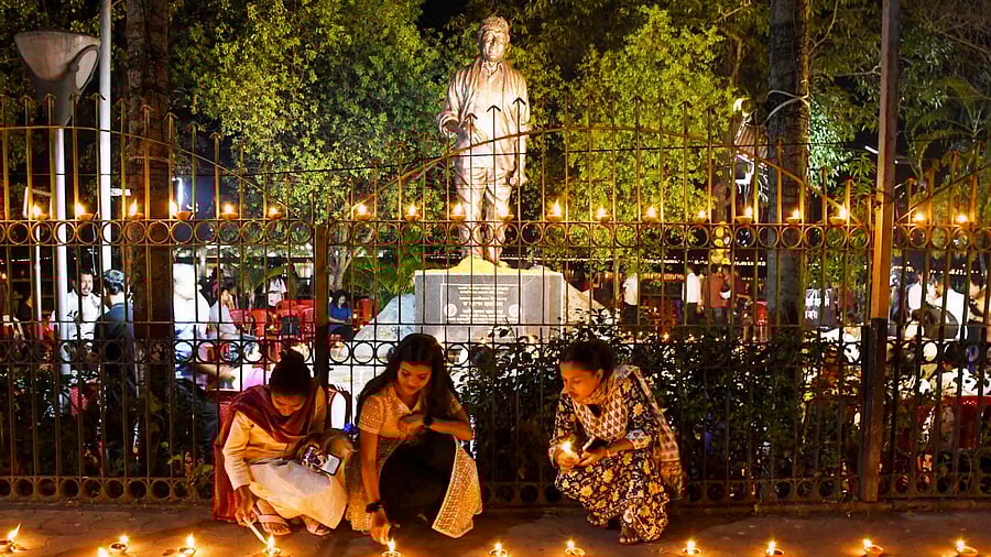 <div class="paragraphs"><p>People lighting diyas (lamps) in front of Bhupen Hazarika's statue.</p></div>