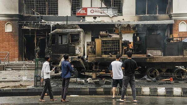 <div class="paragraphs"><p>People take pictures of the charred remains of a bank, a day after it was set ablaze by agitators during anti-government protests, in Kathmandu, Nepal.</p></div>