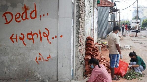 <div class="paragraphs"><p>People clean a street next to a graffiti that reads "dead government", during a curfew.</p></div>
