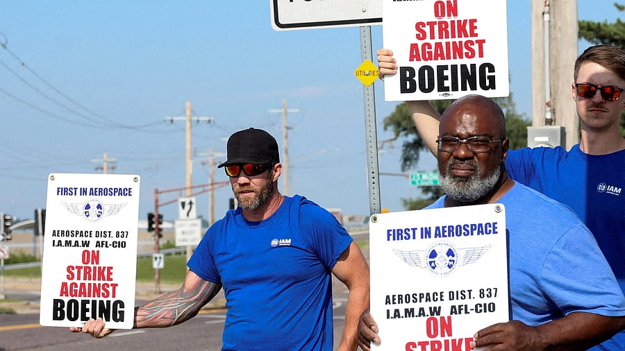 <div class="paragraphs"><p>Workers hold signs during a walkout by members of the International Association of Machinists and Aerospace Workers (IAM) over contract negotiations, outside Boeing company's facility, in Berkeley, Missouri, US.</p></div>