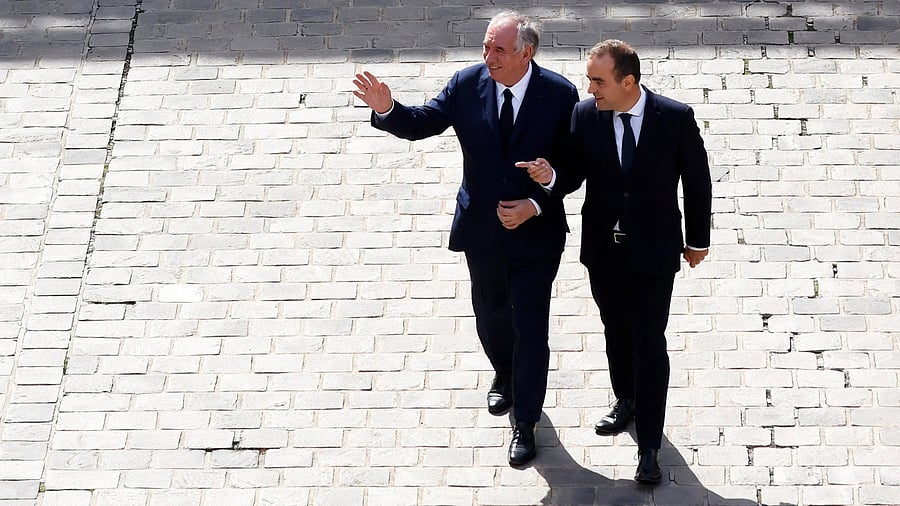 <div class="paragraphs"><p>France's outgoing Prime Minister Francois Bayrou waves to guests as he is escorted towards the exit by France's newly appointed Prime Minister Sebastien Lecornu at the end of the handover ceremony at the Hotel Matignon in Paris.</p></div>