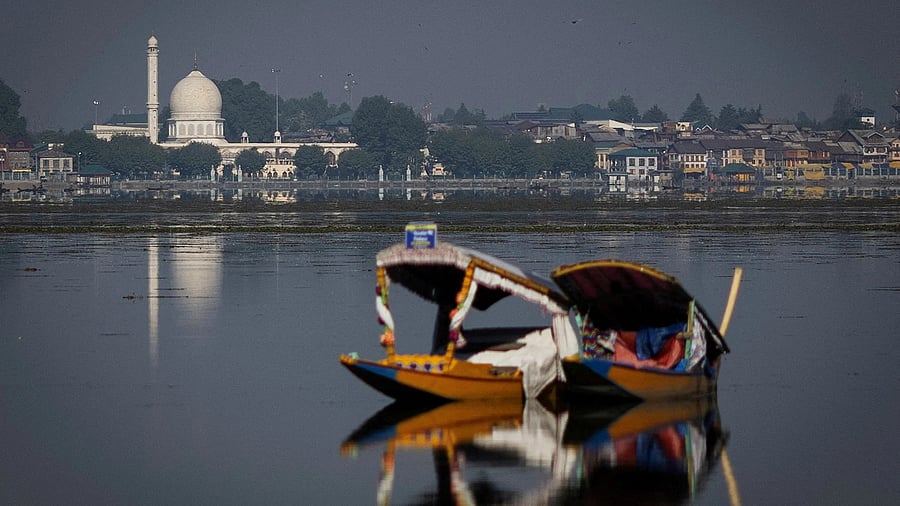 <div class="paragraphs"><p>A traditional Shikara boat is seen in the waters of Dal Lake as the Hazratbal shrine is seen in the background in Srinagar, Kashmir.</p></div>