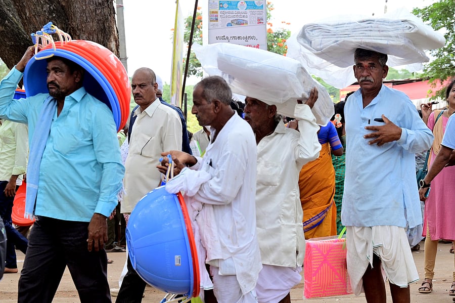 <div class="paragraphs"><p>Farmers carry farm material purchased at the Krishi Mela, organised at University of Agricultural Sciences in Dharwad, on Tuesday</p></div>