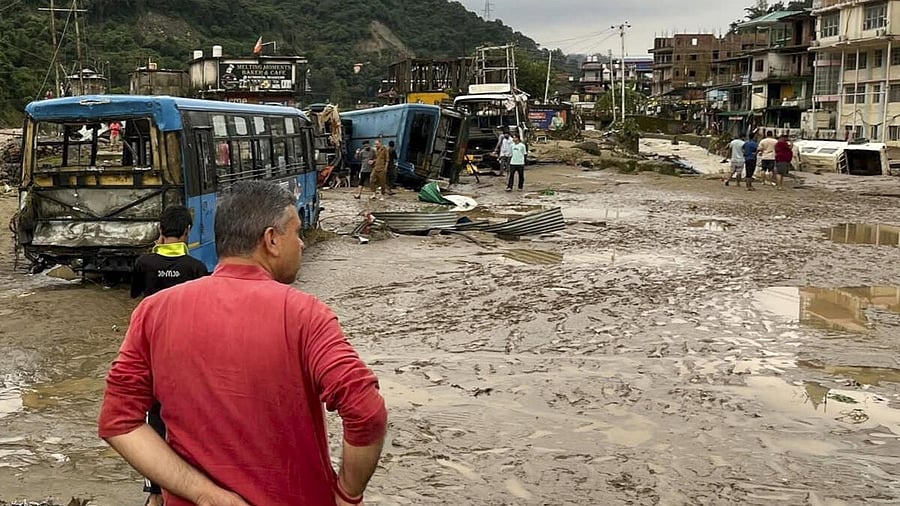 <div class="paragraphs"><p>People near the vehicles damaged due to floods triggered by heavy rains, at Dharampur in Mandi, Himachal Pradesh, Tuesday, Sept. 16, 2025.</p></div>