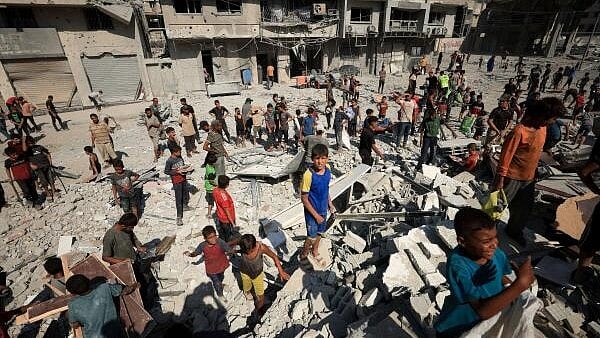 <div class="paragraphs"><p>Palestinians gather at the site of Israeli air strikes on the evacuated Al-Ghefari tower.</p></div>