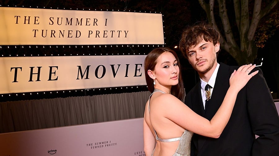 <div class="paragraphs"><p>Lola Tung (Belly) posed on the red carpet in front of a billboard announcing the film accompanied by co-star Christopher Briney (Conrad).</p></div>