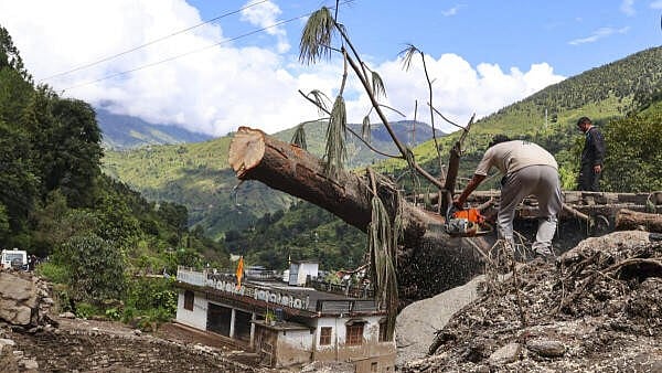 <div class="paragraphs"><p>A man crosses a trunk at the disaster-hit Nandanagar area, in Uttarakhand's Chamoli district</p></div>