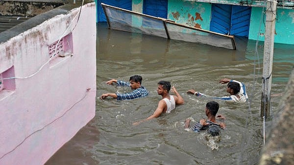 <div class="paragraphs"><p>Residents wade through a waterlogged alley after heavy rainfall in a town in MP. (File image for representation)</p></div>