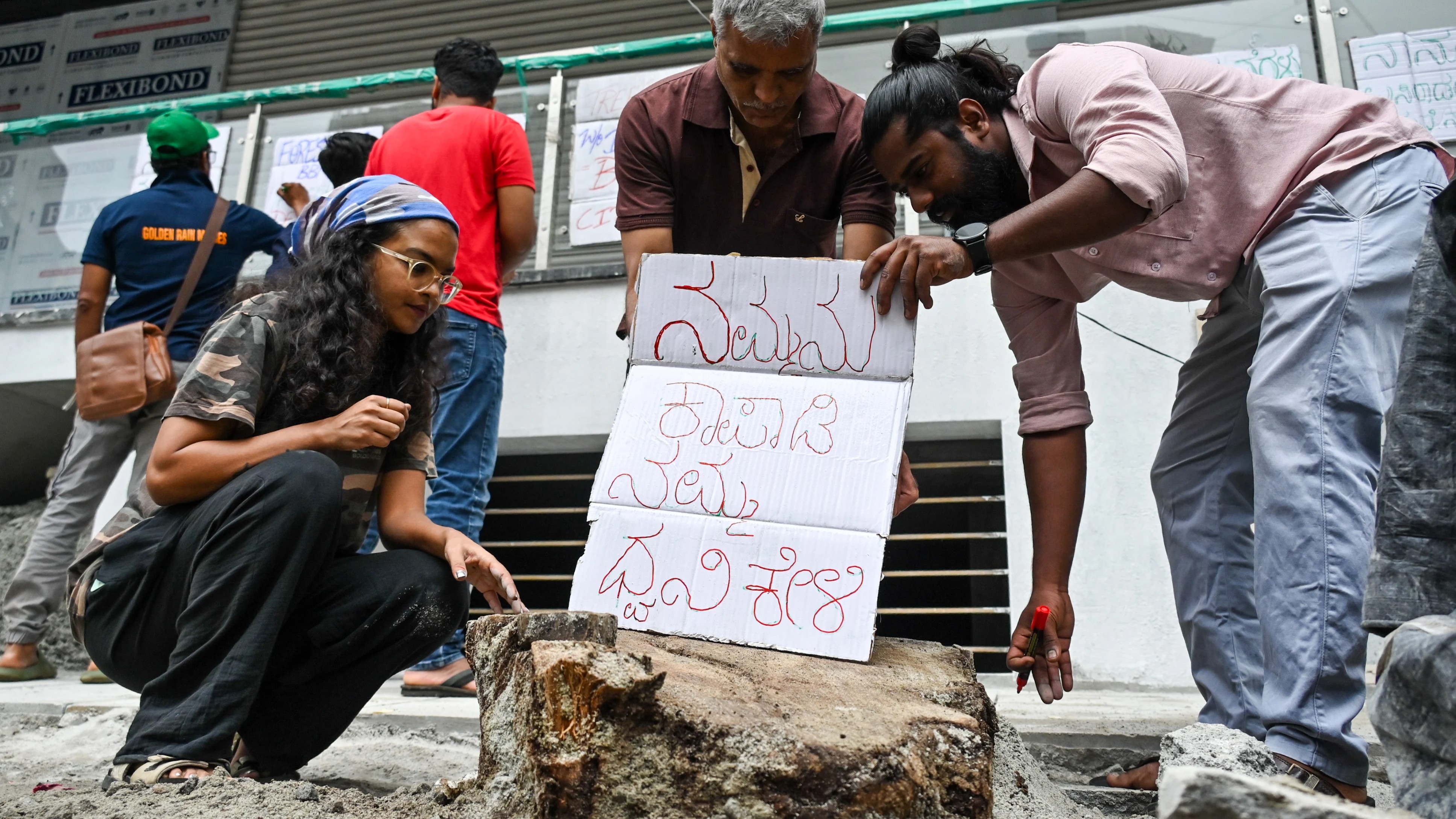<div class="paragraphs"><p>Protesters place placards and banners at Rajarajeshwari Nagar on Sunday. </p></div>