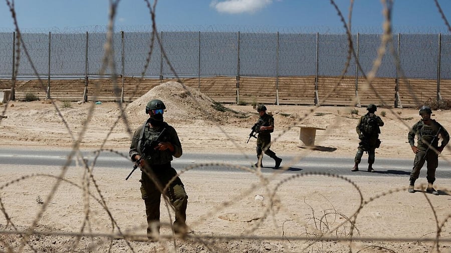 <div class="paragraphs"><p>Israeli soldiers stand guard during a protest, calling for the end of the conflict in Gaza between Israel and Hamas, by the Israel-Gaza border, as seen from the Israeli side</p></div>