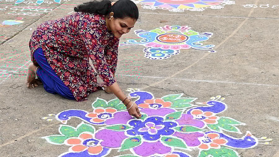 <div class="paragraphs"><p>A participant draws a colourful piece during the rangoli contest organised by the department of women and child development in front of the Mysuru Palace on Tuesday. </p></div>