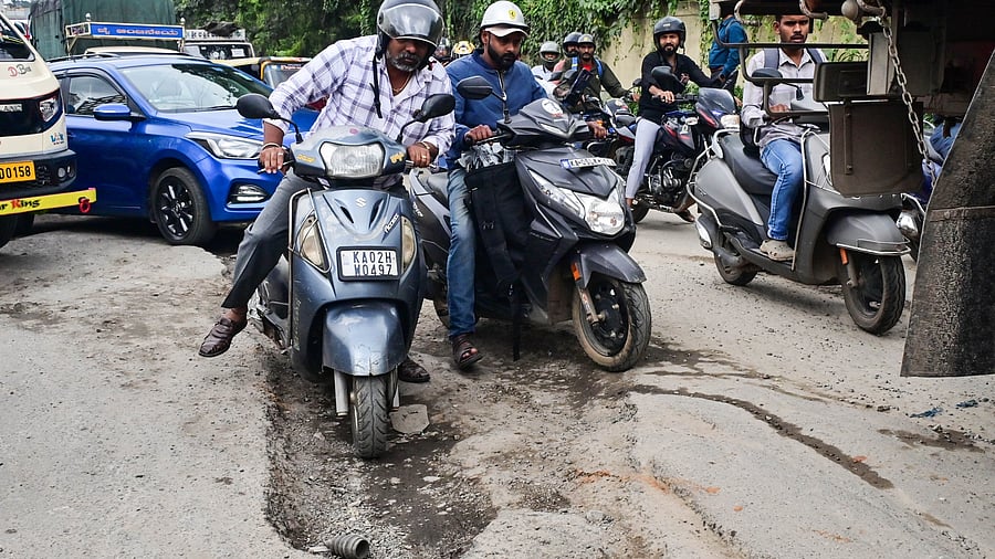 <div class="paragraphs"><p>Two-wheeler riders struggle with deep potholes on the Outer Ring Road near FTI Circle. </p></div>