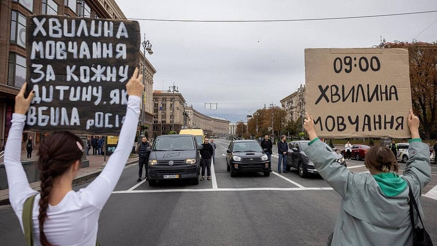 <div class="paragraphs"><p>People hold placards and drivers pause on Khreshchatyk Street to observe a minute of silence in honour of those who were killed during Russia’s attack on Ukraine, in Kyiv, Ukraine.</p></div>